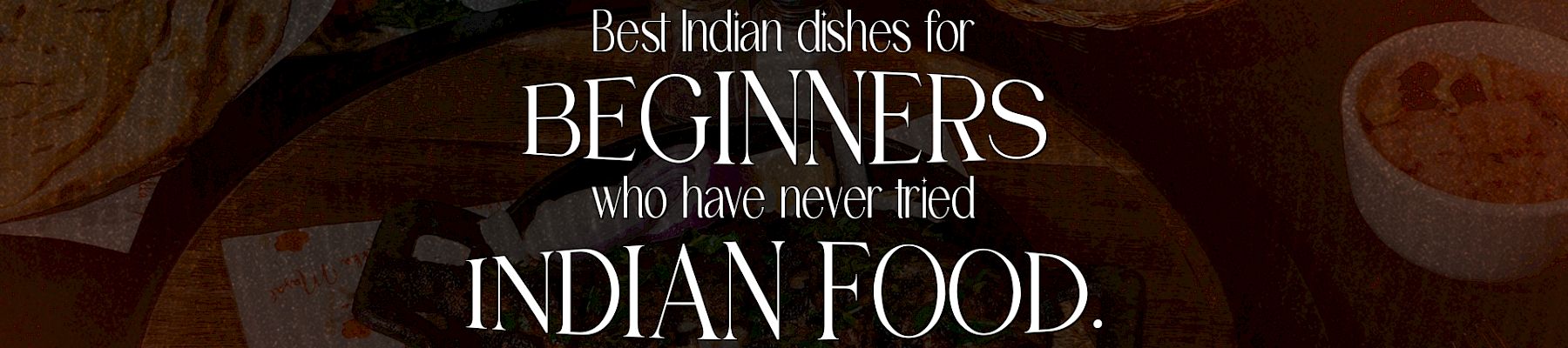 An Indian food spread with spices and bowls, overlaid with text: “Best Indian dishes for beginners who have never tried Indian food.”