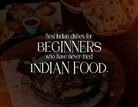An Indian food spread with spices and bowls, overlaid with text: “Best Indian dishes for beginners who have never tried Indian food.”